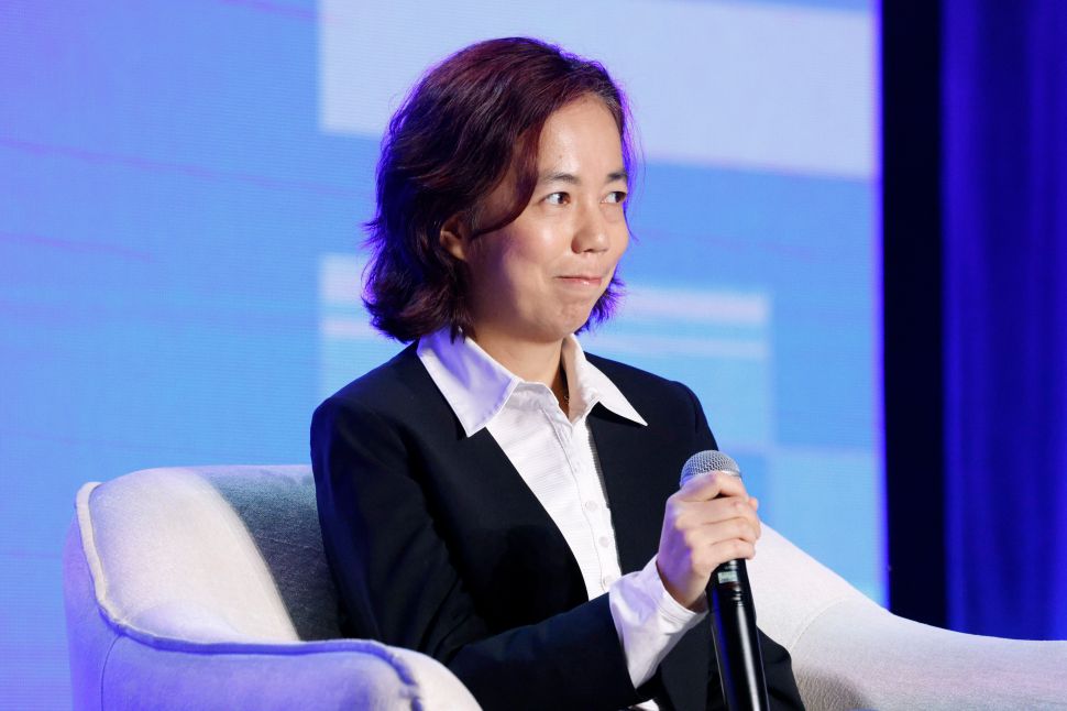 Woman in blazer sits on panel