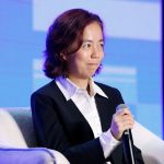 Woman in blazer sits on panel