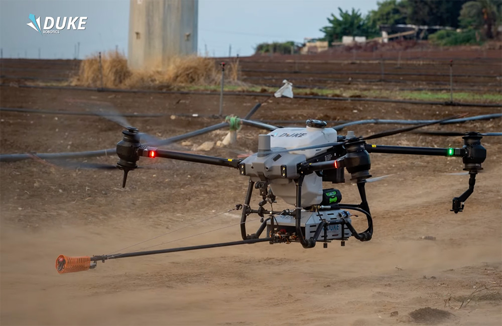 Duke Robotics' Insulator Maintenance Solution, which features a large drone with four propellers, and a hose for spraying.