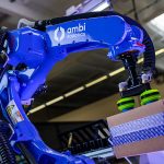 Ambi Robotics 的 AmbiSort A 系列机器人正在抓取一个带有紫色灯光的纸板箱。