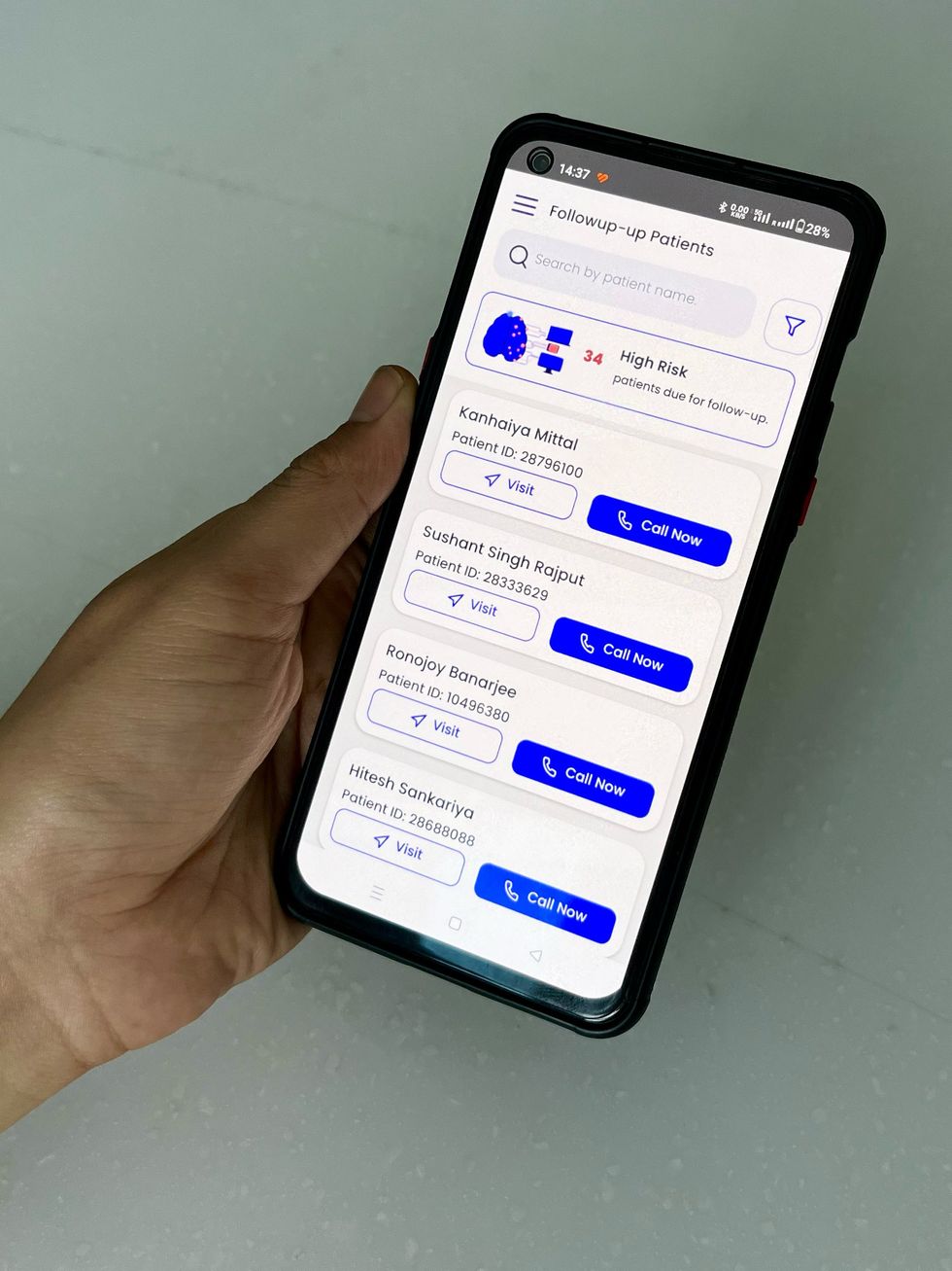 一只手拿着一部智能手机，屏幕上显示着一份患者姓名列表。
