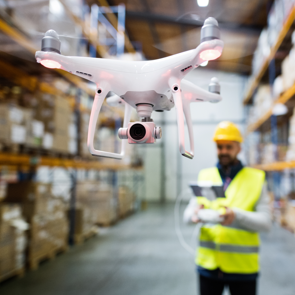 An image of a drone with a man in the background.