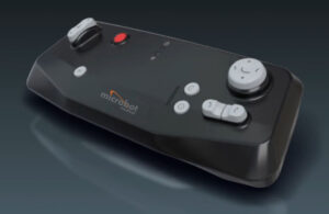 Microbot Medical's Liberty system, which wlooks like a grey controller with a large round button on the right side, and other smaller buttons.