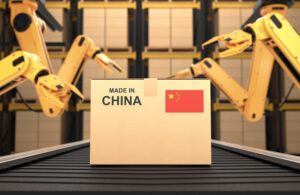 A 3D illustration of a box on a conveyor belt that says "MADE IN CHINA", behind it are four yellow robot arms. Huawei invested in a robotics subsidiary in December 2024.