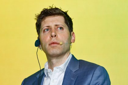 Man in blue blazer pictured against yellow background