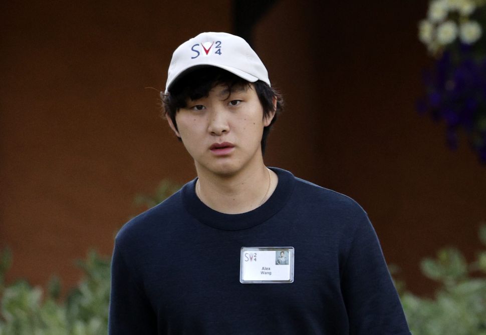 一位戴白色帽子的亚洲男子穿着黑色T恤。