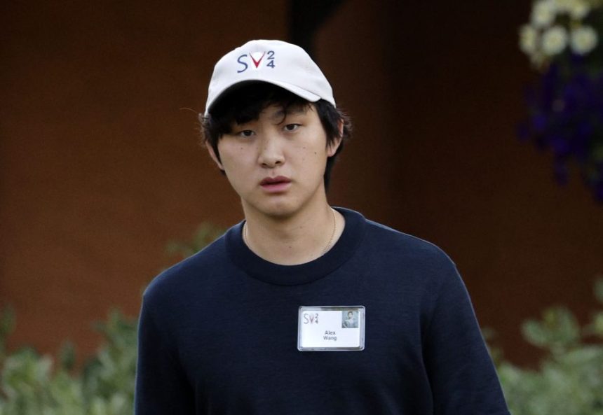 一位戴白色帽子的亚洲男子穿着黑色T恤。