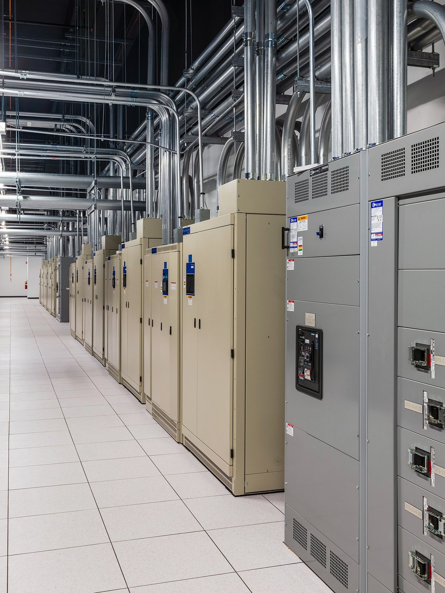 工业服务器机房，灰色机柜，复杂的顶部管道